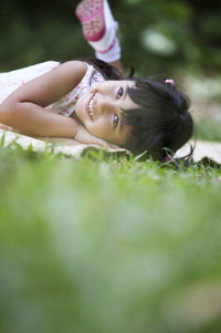 Portrait of smiling girl lying on field