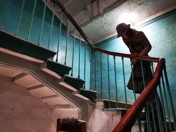 Low angle view of man standing on staircase in building