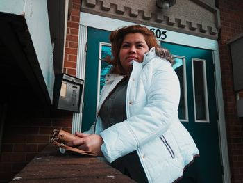 Mid adult woman standing outside building