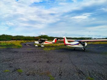 Airplane on airport runway against sky