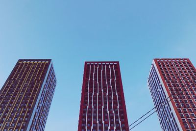 Low angle view of modern buildings against clear blue sky