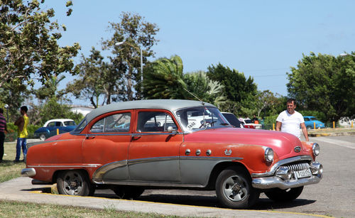 Vintage car against trees in city