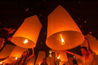 People in illuminated lantern at night