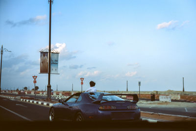 Rear view of vehicles on road against sky