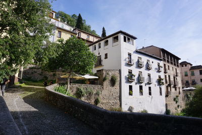Street by buildings against sky