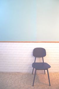 Empty chair against wall