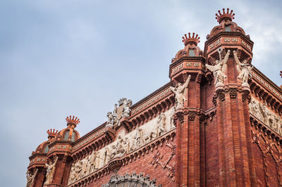 Architectural close-up of the top of the monumental red brick arch of barcelona in spain