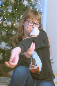 Teenage girl in glasses plays with white pet rat