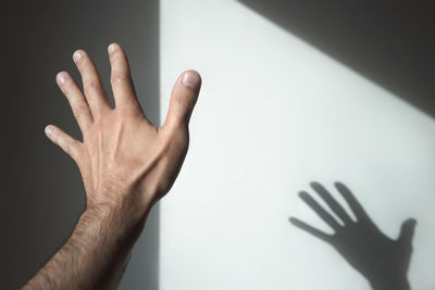 Close-up of hand against wall