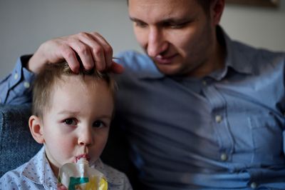 Father sitting with his toddler who is drinking juice