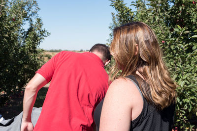 Rear view of couple kissing against trees