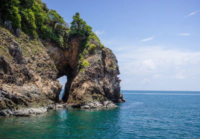 Scenic view of rock formation in sea against sky