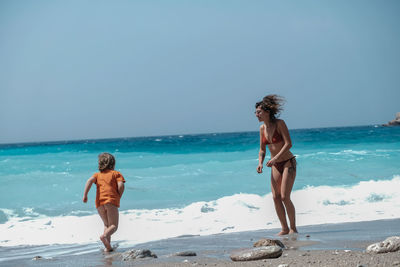 Full length of woman on beach against clear sky