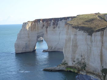 Rock formations by sea against sky