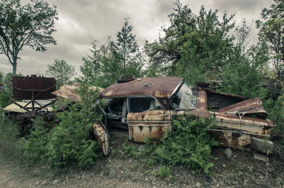 Abandoned house against cloudy sky