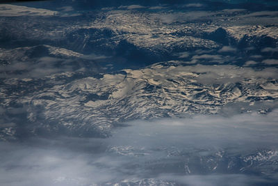 High angle view of snowcapped mountains against sky