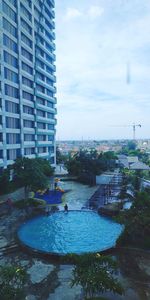 View of swimming pool against buildings in city