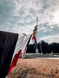 Flags hanging on beach against sky