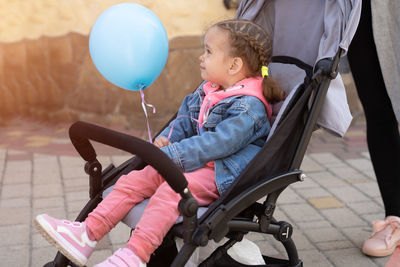 Side view of baby boy sitting on swing