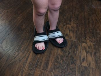 Low section of person standing on hardwood floor