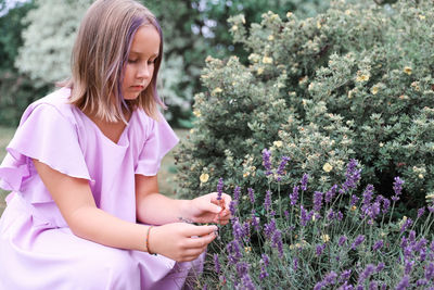 Portrait of young woman standing amidst plants