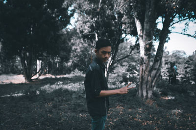 Young man using mobile phone in forest