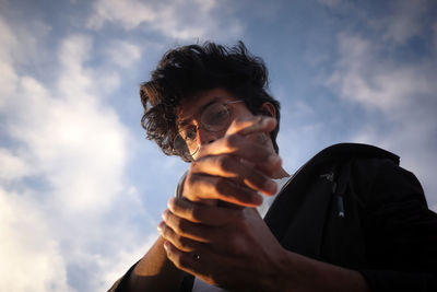 Low angle view of young man against sky