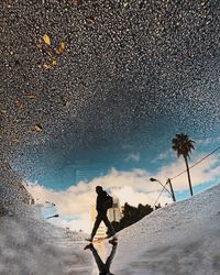 Man walking by water against sky