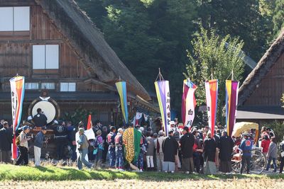 People in traditional windmill against sky