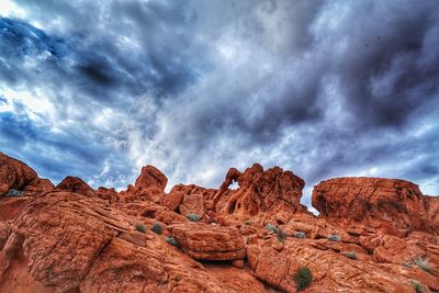 Low angle view of rock formations against cloudy sky