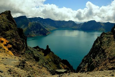 Scenic view of sea and mountains against sky