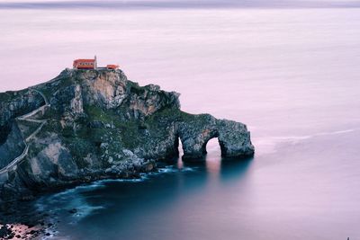 Rock formation in sea against sky