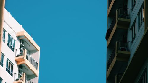 Low angle view of buildings against clear blue sky