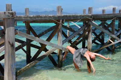 Full length of woman on railing against sea