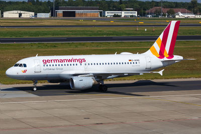 Side view of airplane on airport runway