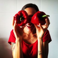 Smiling woman holding red bell pepper