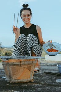 Portrait of smiling young woman sitting on table