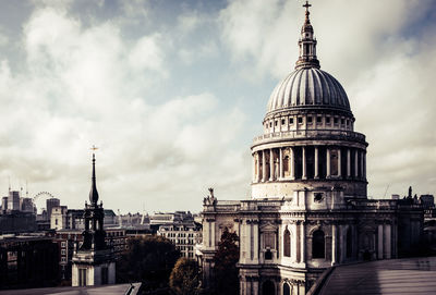 View of buildings in city against cloudy sky