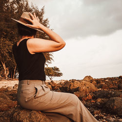 Side view of woman standing on rock