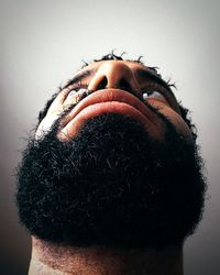 Close-up of man wearing mask against white background