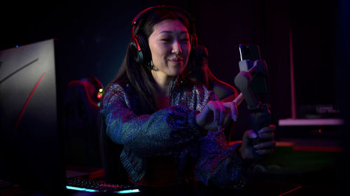 Smiling woman vlogging while sitting at internet cafe