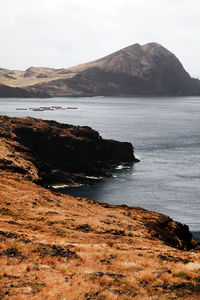 Scenic view of sea and mountains against sky