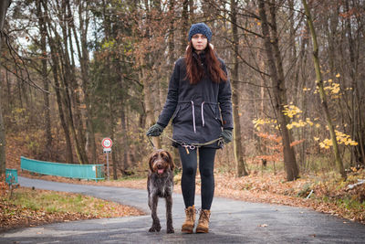 Full length of woman with dog walking outdoors