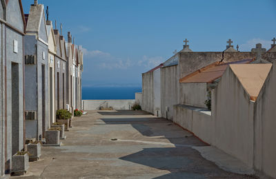 Footpath amidst buildings against sky