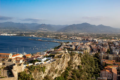 High angle view of townscape by sea against sky