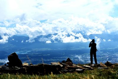 Woman standing on mountain against sky