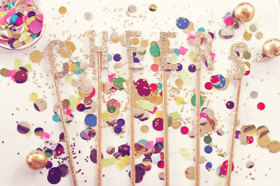Directly above shot of text with confetti on table