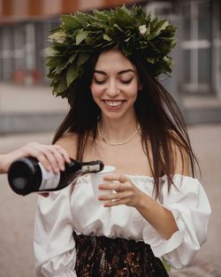 Young woman holding wine standing outdoors