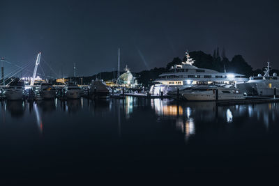 Boats moored in harbor at night