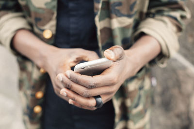 Midsection of student using smart phone